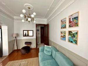 een woonkamer met een blauwe bank en schilderijen aan de muur bij Botter Dream House in Istanbul