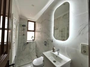 een witte badkamer met een wastafel en een spiegel bij Botter Dream House in Istanbul +8 foto's