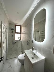 een witte badkamer met een wastafel en een spiegel bij Botter Dream House in Istanbul