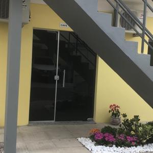 una puerta a un edificio con flores delante en Pousada Mercosul, en Alegrete