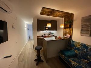 kuchnia oraz salon z kanapą i ladą w obiekcie Apartamento vistas al Mar Aire acondicionado Wifi w mieście Empuriabrava