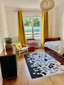 een slaapkamer met een bed, een raam en een tapijt bij GRAND Appartement 85m2 centre ville de BIARRITZ 6 pers in Biarritz