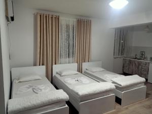 a room with three beds and a mirror at Room Click inn in Gjirokastër