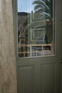 a door with a view of a building through a window at Toscano Palace Luxury Rooms Catania in Catania