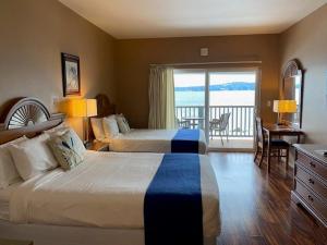 a hotel room with two beds and a balcony at The Waterfront at Potlatch in Shelton