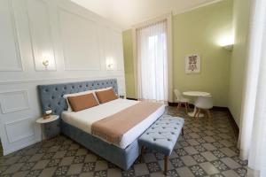 une chambre d'hôtel avec un lit, une table et des chaises dans l'établissement Toscano Palace Luxury Rooms Catania, à Catane