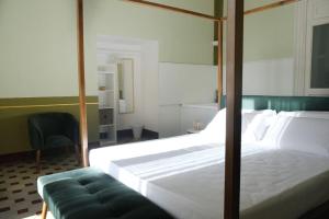 a bedroom with a large white bed and a chair at Toscano Palace Luxury Rooms Catania in Catania