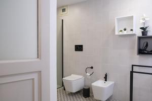 a white bathroom with a toilet and a sink at Toscano Palace Luxury Rooms Catania in Catania