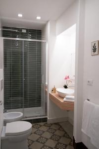 a bathroom with a toilet and two sinks and a shower at Toscano Palace Luxury Rooms Catania in Catania
