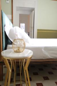 a bed with a table in front of a bed at Toscano Palace Luxury Rooms Catania in Catania