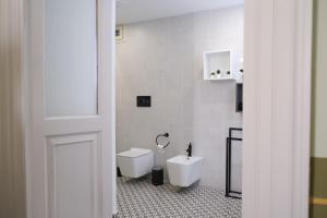 a white bathroom with a toilet and a sink at Toscano Palace Luxury Rooms Catania in Catania