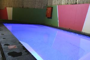 a swimming pool with blue water in a room at TaTe Village in Windhoek