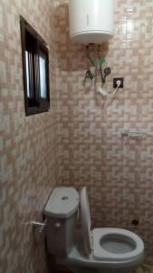 Baño con aseo con una luz sobre él en STUDIO 2 Climatisé et Ventilateur Plafonnier et WIFI GRATUIT A 6 NUITEES DE RESERVATION en Lomé