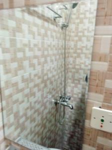 y baño con ducha y pared de azulejos. en STUDIO 2 Climatisé et Ventilateur Plafonnier et WIFI GRATUIT A 6 NUITEES DE RESERVATION en Lomé