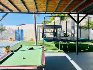 a pool table and a swing in a backyard at Casa Flamboyant With Sea Views & Heated Pool in Adeje