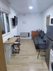 uma sala de estar com um sofá, uma mesa e cadeiras em Apartamento-Estudio B-3. em Madri