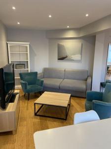 sala de estar con sofá, sillas y mesa en Appartement Roland-Gaross/Boulogne-Billancourt, en Boulogne-Billancourt
