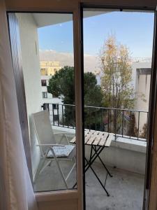 d'un balcon avec une chaise et un banc. dans l'établissement Appartement Roland-Gaross/Boulogne-Billancourt, à Boulogne-Billancourt