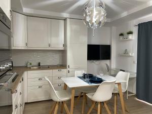 cocina con mesa blanca y sillas blancas en SAN AGUSTIN SEAVIEW BLUE APARTMENT en Maspalomas