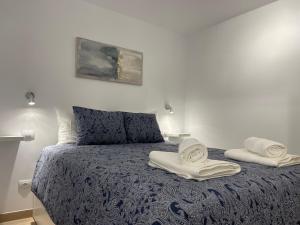 1 dormitorio con 1 cama con toallas en SAN AGUSTIN SEAVIEW BLUE APARTMENT en Maspalomas