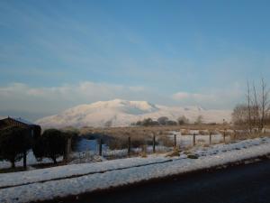 a snowy road with a mountain in the background at Troutbeck Inn in Troutbeck