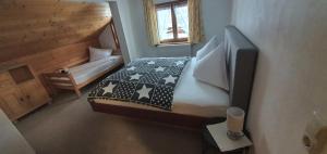 Ferienwohnung Zunzer في ميتلبرغ: غرفة نوم صغيرة بها سرير وتلفزيون