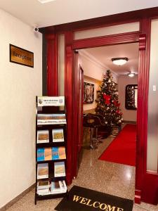 a room with a christmas tree and a room with a book shelf at HOTEL LYBETEN in Ferizaj