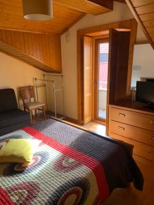 1 dormitorio con 1 cama y TV en una habitación en Recantos da Estrela, en Sabugueiro