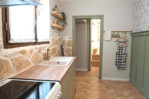 eine Küche mit einem Waschbecken und einer Steinmauer in der Unterkunft locanta in Ioannina