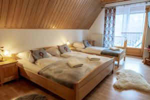- une chambre avec un grand lit et une grande fenêtre dans l'établissement Bylinkowa Chata Jacuzzi & Sauna, à Poronin