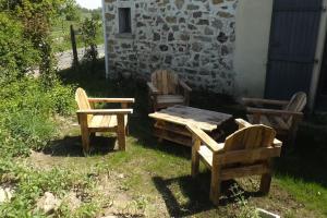 a group of chairs and a wooden table and chairs at Gite Les Fées - 6 Personnes maxi in Grand-Landes