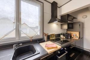uma cozinha com um lavatório e uma grande janela em LE NID DOUILLET : PARIS proche-Cozy-Netflix em Montmagny