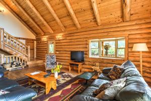 a living room with a couch and a tv in a cabin at Log Home on 40 Private Acres By Mt Shasta Ski Park in McCloud