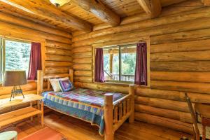 1 dormitorio con 1 cama en una cabaña de madera en Log Home on 40 Private Acres By Mt Shasta Ski Park, en McCloud