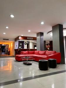 - un salon avec un canapé rouge et une table dans l'établissement HOTEL IMPALA DE TAMPICO, à Tampico