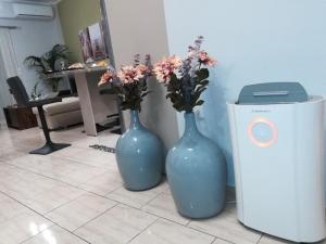 two blue vases sitting on a tile floor with flowers in them at Nemeapolis 1 apt in Neméa