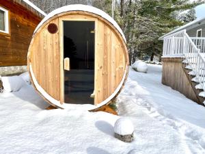 a wooden sauna in the snow next to a house at Muskoka Lakefront 3-bdrm Chalet in Port Carling