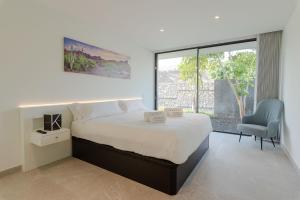 a bedroom with a bed and a chair and a window at Karat Villa Macaronesia in Adeje +32 photos
