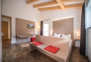 een slaapkamer met een groot bed met rode kussens bij Alpenblick Nr 9 in Campo Tures