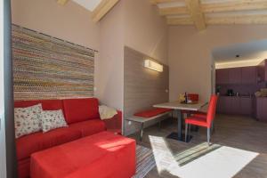 een woonkamer met een rode bank en een tafel bij Alpenblick Nr 9 in Campo Tures