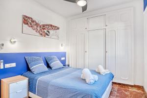 a bedroom with two white towels on a blue bed at Perla del Mar Calpe in Benissa +32 photos