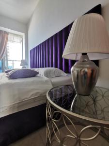 - une chambre avec un lit et une table avec une lampe dans l'établissement Serenity 3BR Palm view in Marina, à Dubaï