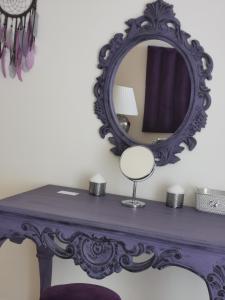 une table violette avec un miroir au-dessus dans l'établissement Serenity 3BR Palm view in Marina, à Dubaï