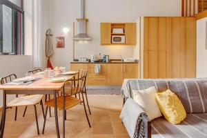 cocina y comedor con mesa y sofá en Calheta Lofts ii, en Calheta