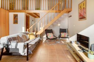 a living room with a couch and a staircase at Calheta Lofts ii in Calheta