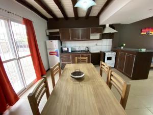 a kitchen with a wooden table with chairs and a refrigerator at Raíces in San Rafael