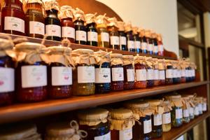un estante lleno de muchas botellas de miel en Natura Family Resort en Avrig