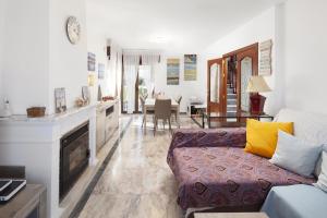 Villa Jacaranda في تشايلتشيس: غرفة معيشة مع أريكة ومدفأة
