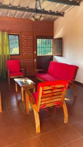 sala de estar con sillas rojas y sofá rojo en Casa de la Luna, Juayúa., en Juayúa
