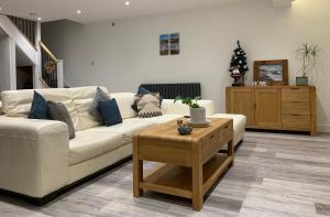 a living room with a white couch and a coffee table at Surfers Lodge - Rest Bay, Porthcawl in Porthcawl